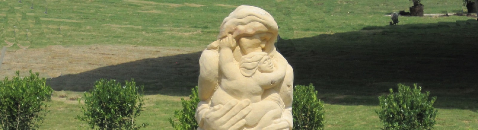 A Limestone Mother and Child site-specific sculptures installed at Newman Village in Frisco, TX